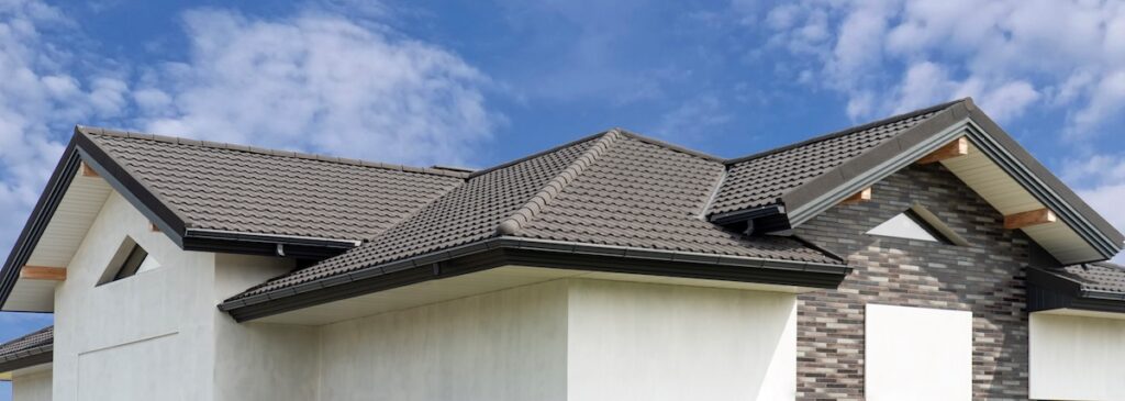 Gray composite roof tile with wave profile on modern house