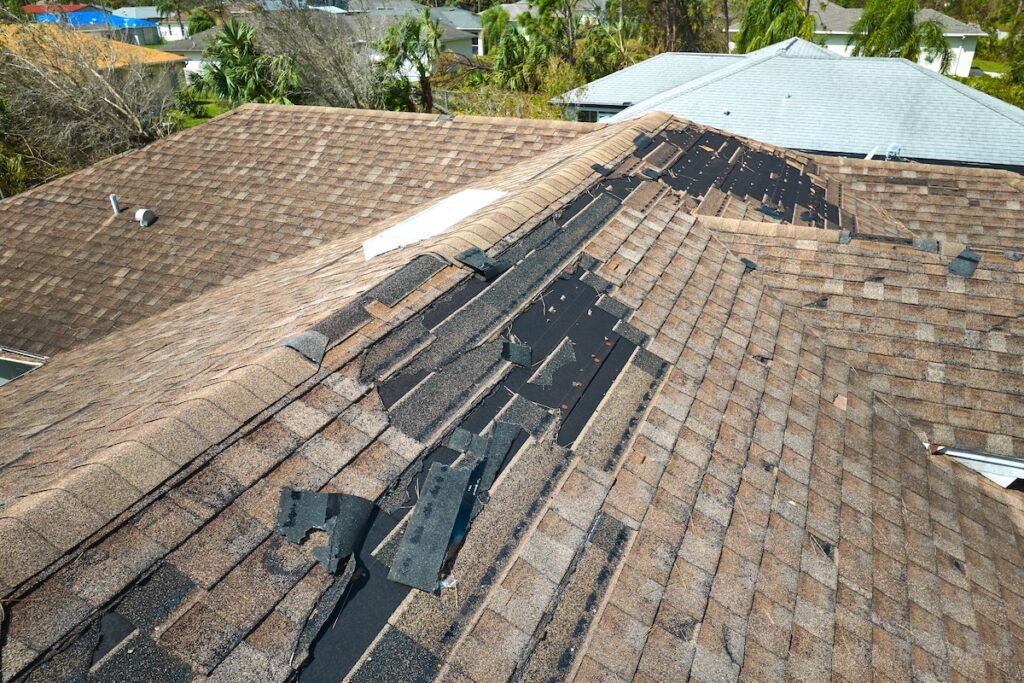 Damaged house roof with missing shingles 